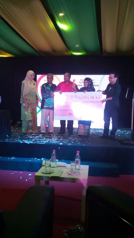 Nor Azhar Ishak receiving the best children's book award for Under The Sea in the 6-12 years category